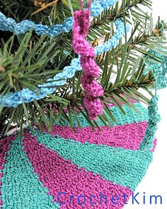 a crocheted christmas ornament hanging from a pine tree