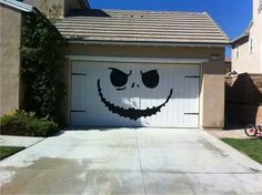 a garage with a smiley face painted on the front door and side of the house