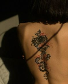 a woman with a dragon tattoo on her back