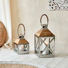 two metal lanterns sitting on top of a white floor