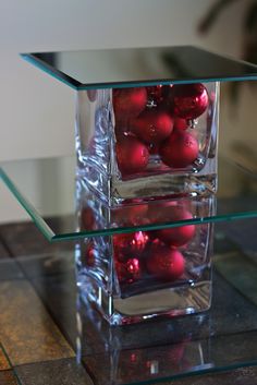 some red ornaments in a clear glass vase