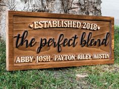 a wooden sign that reads, established the perfect blend aby, and sits in front of a tree