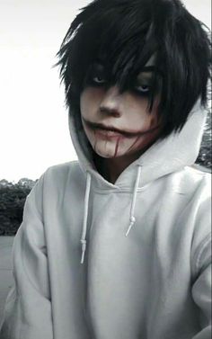 a person with black hair wearing a white hoodie and face paint on their face