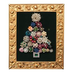 a christmas tree made out of beads in a gold frame on a black background with an ornament embellishment