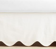 a white bed skirt with scalloped edges