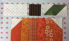 an orange patchwork quilt with several different patterns and colors on it, along with two strips of fabric