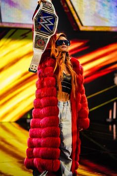 the woman is wearing a red fur coat and holding up a large pair of skis