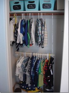 an image of a closet with clothes hanging on the rack and other items in it