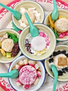 four bowls filled with different types of food on top of a plate next to spoons