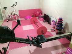 a pink gym room with exercise equipment on the floor