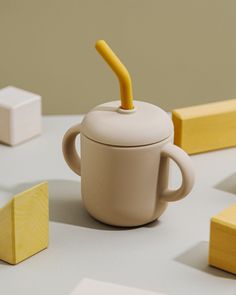 a cup with an umbrella sticking out of it sitting on a table next to blocks