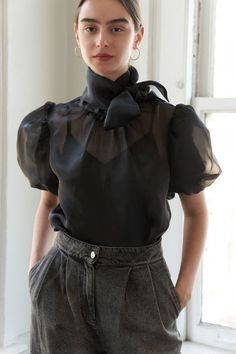 A solid woven organza blouse featuring front bow tie, short puff sleeve, back neck button closure and cami Details: SELF: 90% POLYESTER 10% SPANDEX LINING:100% POLYESTER Size & Fit - Model is 5'9" And Wearing Size Small - Measurements Taken From Size Small Approx. center front length: 9 1/4". Organza Top Outfit, Organza Blouses, Organza Top Styles, Organza Outfit, Organza Tops, Organza Jacket, Organza Bow, Polka Dot Midi Skirt, Black Attire