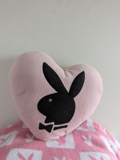 a pink heart shaped pillow with a black rabbit on it