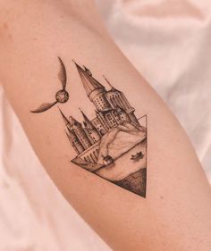 a tattoo on the arm of a woman with a castle and bird flying over it