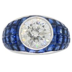 Vintage approximately 2.62CT Round Brilliant Cut diamond ring with blue sapphires set in a mosaic design crafted in platinum Gemstone: Diamond and Sapphire Gemstone Size: Irregular Cut Blue Sapphires ranging from approximately 2.00-2.4mm in size Center Diamond Carat Weight: Approximately 2.62CT Center Diamond Cut: Round Brilliant Cut Center Diamond Color: H-I Center Diamond Clarity: I1 Metal: Platinum Ring Size: 6.5 Marked/Tested: Stamped "PLAT" Weight: 12.2 Grams Luxury Modern Sapphire Ring With Single Cut Diamonds, Luxury Multi-stone Sapphire Ring In Platinum, Sapphire Ring Vintage 1stdibs, Luxury Brilliant Cut Platinum Gemstones, Luxury Lab-created Sapphire Ring With Diamond Cut, Luxury Sapphire-colored Diamond Ring With Diamond Cut, Luxury Sapphire-colored Diamond Ring, Luxury Sapphire Diamond Ring With Diamond Cut, Luxury Brilliant Cut Sapphire Gemstones