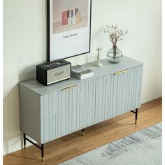 a grey sideboard with two drawers and a radio on top next to a rug