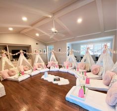 a room filled with lots of pillows and teepees on top of wooden floors