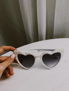 a pair of heart shaped sunglasses sitting on top of a table