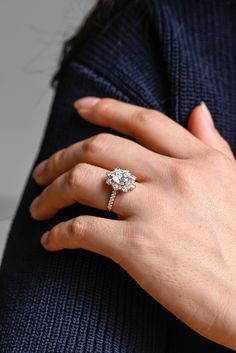 a woman's hand with a diamond ring on it