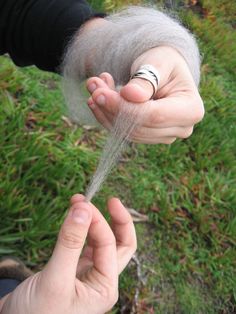 someone is holding out their hand with the thread coming out of it to dry off