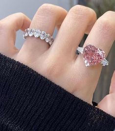 a woman's hand with a pink diamond ring on top of her left hand