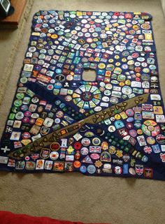 there is a very large piece of art made out of buttons on the floor with a pair of scissors in it