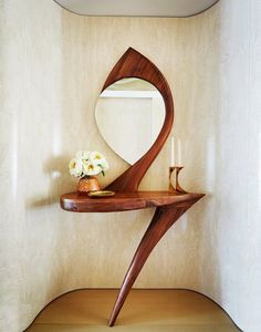 a wooden table with a mirror and vase on it