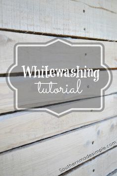 the words whitewashing on wood are displayed in front of a wooden plank wall