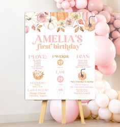 a pink and white first birthday party sign surrounded by balloons