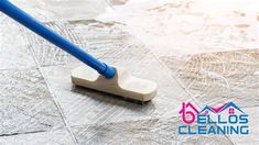 a person using a mop to clean the floor in front of a tile background