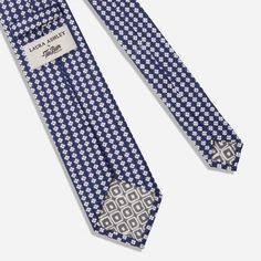 The English Garden Collection: A captivating collection that intertwines Laura Ashley’s iconic floral patterns with Tie Bar’s distinguished craftsmanship. | Men's Tie Bar: Laura Ashley x Tie Bar Humble Daisy Tie - Modern, In Navy, Cotton, Floral Elegant Blue Cotton Suit And Tie Accessories, Classic Blue Suit And Tie Accessories For Summer, Classic Blue Cotton Tie, Elegant Blue Cotton Ties, Classic Floral Print Ties, Elegant Luxury Patterned Ties, Adjustable Blue Floral Print Tie, Luxury Classic Patterned Ties, Navy Tie