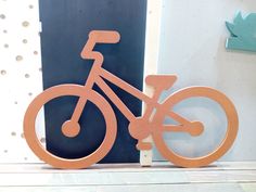 a wooden bike sculpture sitting on top of a table next to a blue and white wall