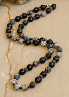 "Jackson" is a new addition to our evolution collection. Gray and black jasper and black onyx. Necklace available in 24" or 30" lengths. Coordinating bracelets and necklace sold separately. With every purchase, a donation is made to plant a tree through our partnership with One Tree Planted. Luxury Onyx Beaded Necklace, Luxury Black Necklaces With Natural Stones, Black Polished Beads Necklace For Meditation, Black Obsidian Necklace With 8mm Beads, Black Obsidian Necklace With 108 Beads, Black Hematite Jewelry For Meditation, Spiritual Black Onyx Beaded Necklace, Adjustable Black Agate Necklace, Black Polished Beads Necklace For Healing