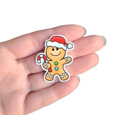 a hand holding a small sticker with a christmas ginger on it's face