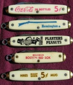 four knives are lined up next to each other on a purple cloth with the words planters peanuts printed on them