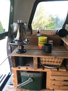 the inside of an rv with wooden crates and containers on it's side table