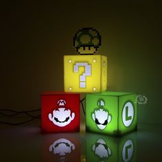 three illuminated cubes with mario and luigi faces on them, all in different colors