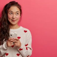 a woman holding a cell phone with hearts on it