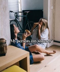 two women sitting on the floor eating pizza and drinking beer, one woman has her hand up to her mouth