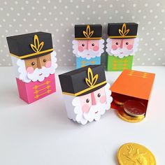 three small boxes are decorated with paper and gold trimmings, one has an image of santa claus on it