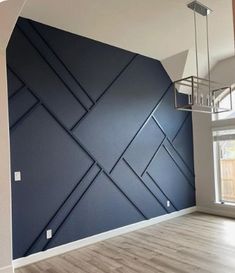 an empty room with blue walls and wood floors