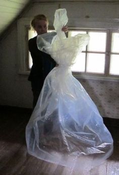 a woman holding a plastic bag in an attic