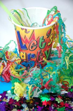 a paper cup filled with confetti and streamers