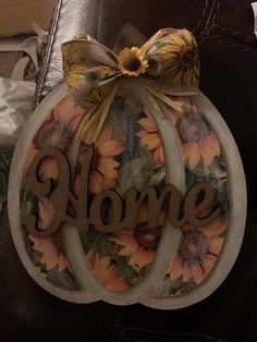 a decorative pumpkin with the word home painted on it and sunflowers around it