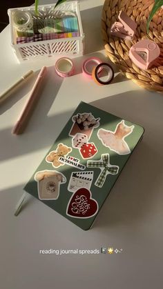 an assortment of stickers on a table next to a basket with flowers and scissors