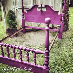 a purple bed frame sitting in the grass