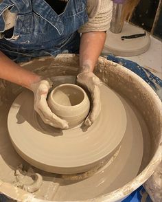 a woman is making a pot on a potter's wheel