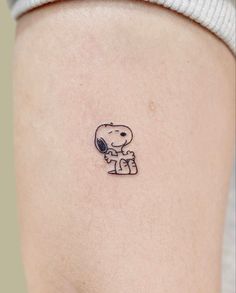 a small tattoo on the back of a woman's left thigh, depicting an elephant and a dog