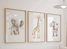 three framed pictures hang on the wall above a bed in a child's room