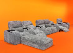 an orange room with three recliners and two chairs in the same color scheme